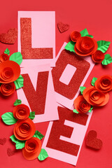 Word LOVE with paper roses and hearts on red background. Valentine's Day celebration