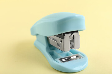 Blue stapler on yellow background