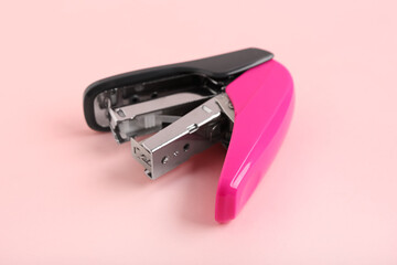 Pink stapler on color background