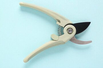 Grey secateurs on blue background