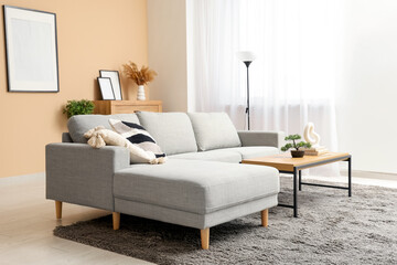 Interior of stylish living room with grey sofa, coffee table and picture