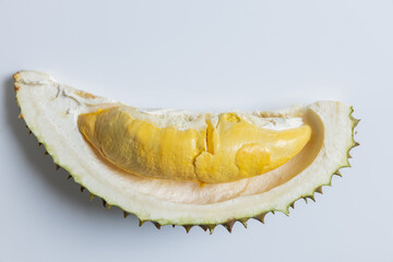 A single pod of durian fruit is shown nestled in its open spiky shell on a white background. The creamy yellow flesh is rich, soft, and aromatic—commonly enjoyed as a tropical delicacy.