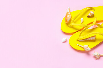 Beach flip-flops and seashells on pink background