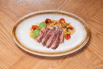 Grilled Beef Steak with Spaghetti Pasta on Rustic Plate