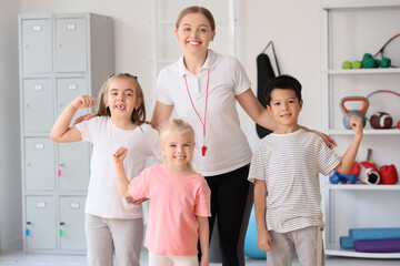 Cute little children with trainer in gym