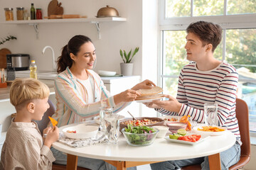 Happy family eating Fajita at table in kitchen