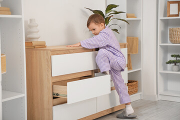 Cute little boy climbing on commode at home. Child in danger