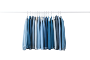 Collection of assorted denim and cotton shirts on a clothing rack, cut out