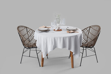 Served restaurant table with flowers in vase on light background