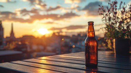 A beer bottle placed on a rooftop garden table at sunset