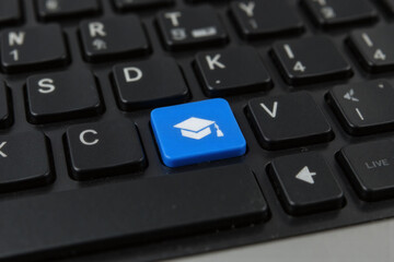 blue computer keyboard with a graduation cap on it