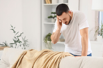 Young man suffering from headache at home