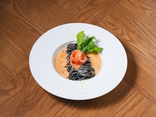 Squid Ink Pasta with Smoked Salmon and Cream Sauce on White Plate