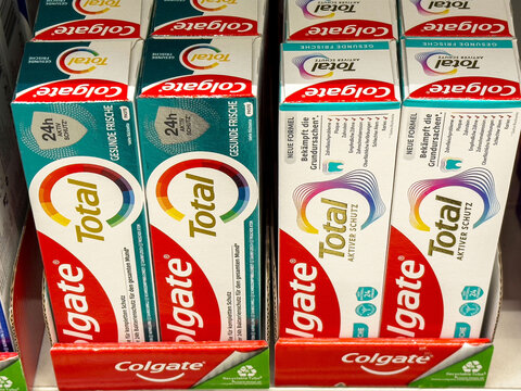 Colgate total toothpaste display in store aisle with multilingual packaging
