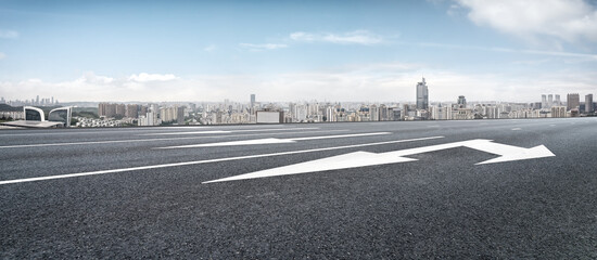 Empty City Road with Urban Skyline