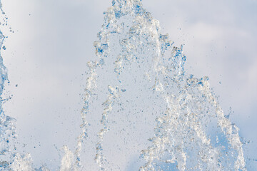 Splashes and jets of water against light background.