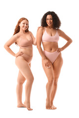 Young body positive women in underwear on white background
