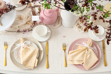 Table setting with blossoming branches and chess pieces, top view