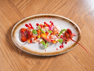 Gourmet Lobster with Vegetables and Red Sauce on Modern Ceramic Plate