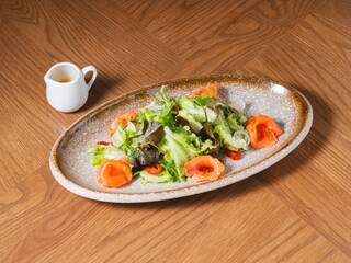 Smoked Salmon Salad with Mixed Greens and Dressing on Rustic Plate