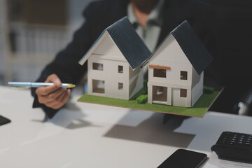 Real estate agents explain models of housing estates in projects to elaborate to clients,...