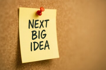 Sticky Note with Handwritten Text Next Big Idea on Cork Board for Creativity and Inspiration