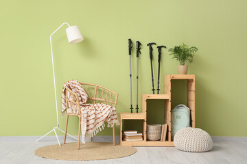 Interior of living room with Nordic walking poles, armchair and lamp