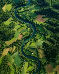 Obraz premium Aerial View of a Winding River Through Lush Green Farmland