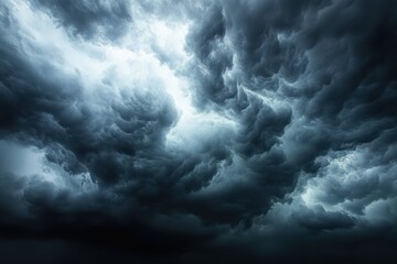 Obraz premium Dark, turbulent storm clouds forming a dramatic and ominous sky filled with swirling textures and deep shadows, evoking a sense of impending severe weather