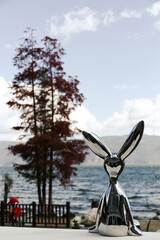 chrome rabbit sculpture by the lakeside