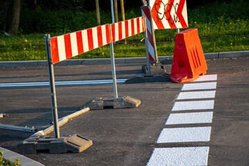 Closed road with red and white barriers blocking entry, indicating roadwork or renovation, viewed...