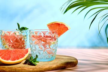 A chilled summer cocktail or drink with fresh grapefruit slices and ice cubes. Refreshing citrus soda