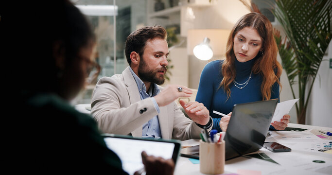 Business, teamwork or planning with laptop in office at night for marketing campaign, design feedback and strategy. Graphic designer, people and discussion for brand development, ideas and overtime