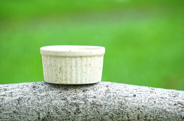 Ceramic cup placed in the garden with a green grass background. Can be used as an illustration to...