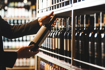 Close-Up of Sommelier Examining Wine Bottle in Cellar Environment