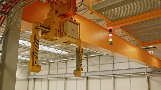 Panning over a still standing overhead crane bridge in a large warehouse