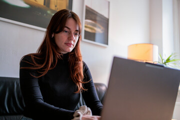 Brunette woman working on a laptop in a cozy home office setting
