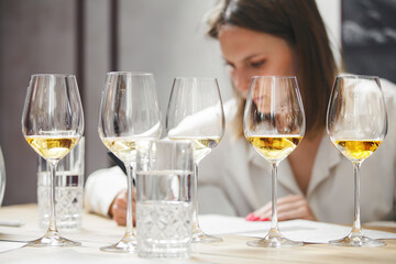 Female sommelier tasting wine during training wine school. Alcoholic beverages degustation courses. Winemaking school, wine waiter certification.