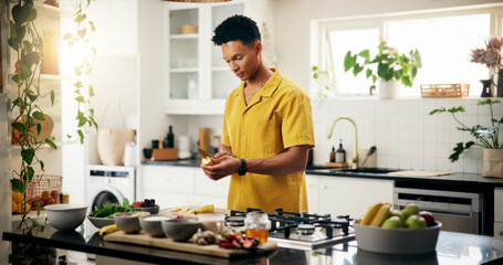 Banana, cooking and concentration with man in kitchen of home for hobby, meal prep or nutrition. Ingredients, peeling and recipe with person in apartment for diet, health or supper as culinary chef