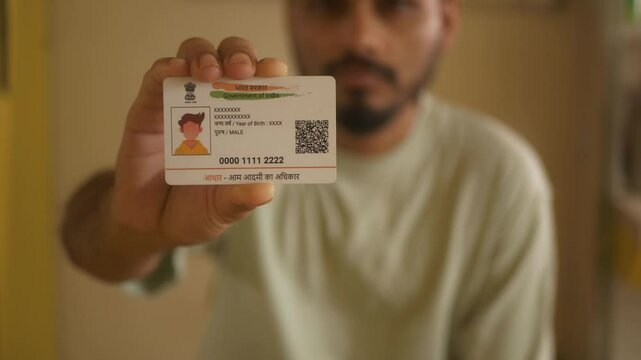 Indian nationality man holding Aadhaar card, closeup