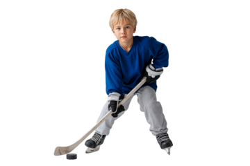 Young boy in blue jersey and ice skates playing hockey, holding a stick and focused on the puck, isolated on white background