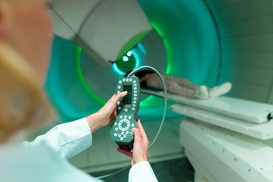Doctor operating proton therapy equipment for cancer treatment in a medical facility