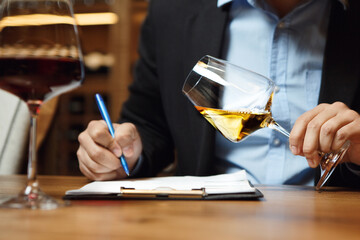 Sommelier Writing Notes With Glass of Wine