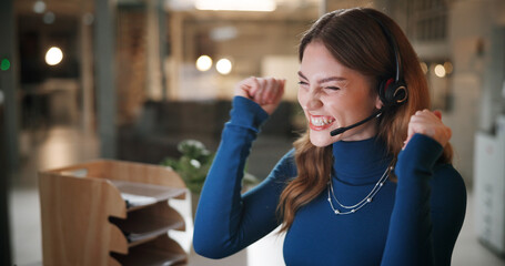 Happy woman, consultant and night with headset for winning, bonus or promotion at call center office. Excited, female person or agent working late with smile or fist pump for success at workplace