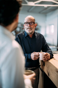 Engineers having a conversation over coffee in an office setting