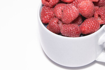 Fresh raspberry berries close up. fragment of a large mug filled with berries