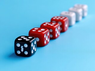 row of black, red, and white dice lined up on a blue surface with shallow focus creating a sense of depth