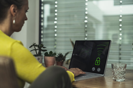 Woman accessing home automation security system on laptop