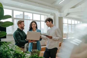 Colleagues discussing work on a laptop in a modern office
