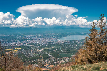 Vue panoramique spectaculaire du bassin genevois depuis le Salève, révélant la ville de Genève, le lac Léman et les montagnes environnantes sous une lumière naturelle et dégagée.